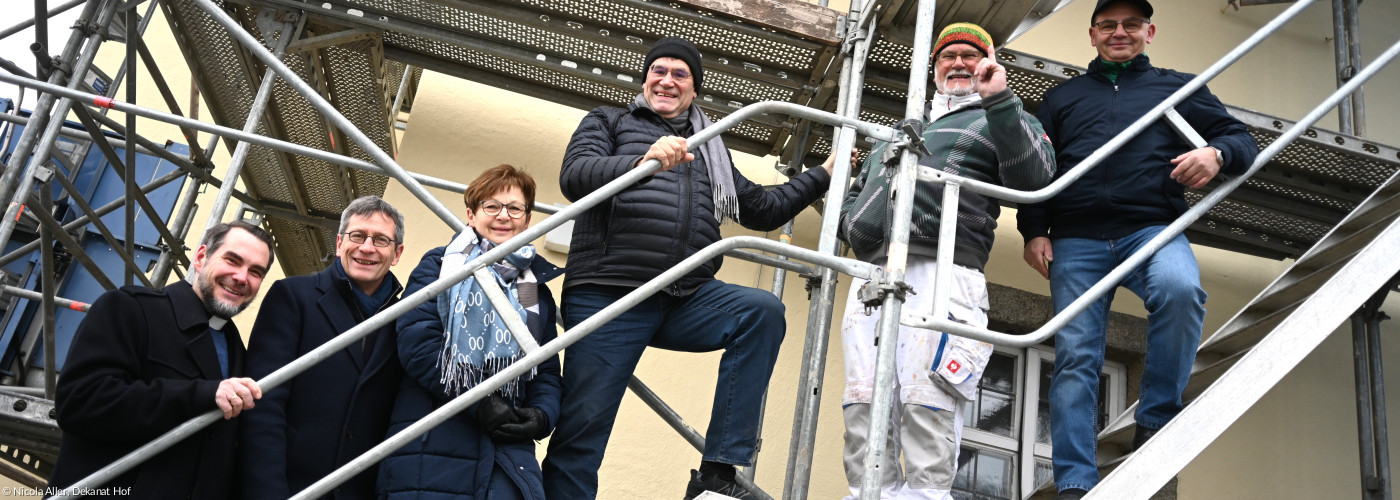 Menschen stehen auf einem Baugerüst